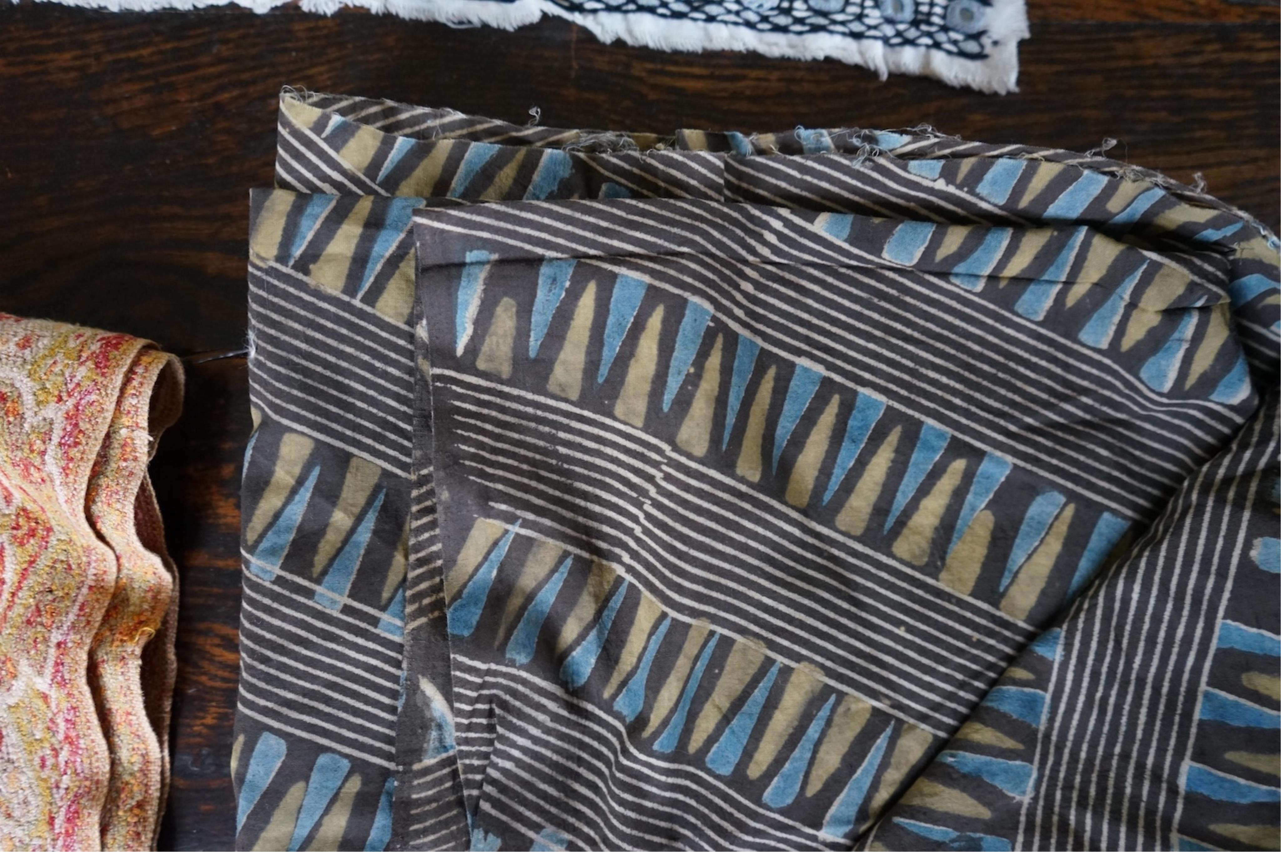 A long narrow length of grey Ikat woven fabric, a roll of Indian mirrored edging, a geometric batik printed length and a woven paisley ‘style’ tasselled stole. (4). Batik 392cm long x 108cm wide., Condition - good, all a